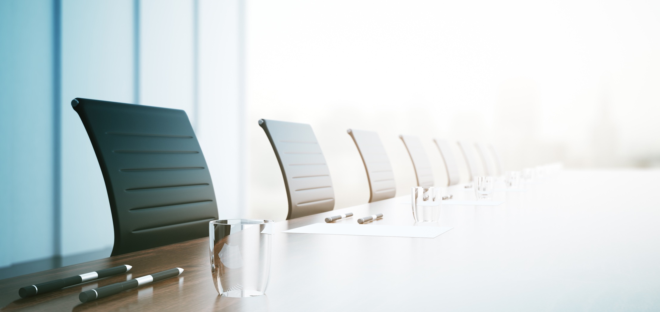 Line of pushed in chairs at a conference room table