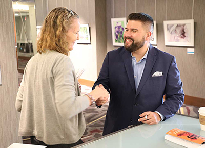 A gentleman is shaking a woman’s hand as part of improving donor retention efforts.